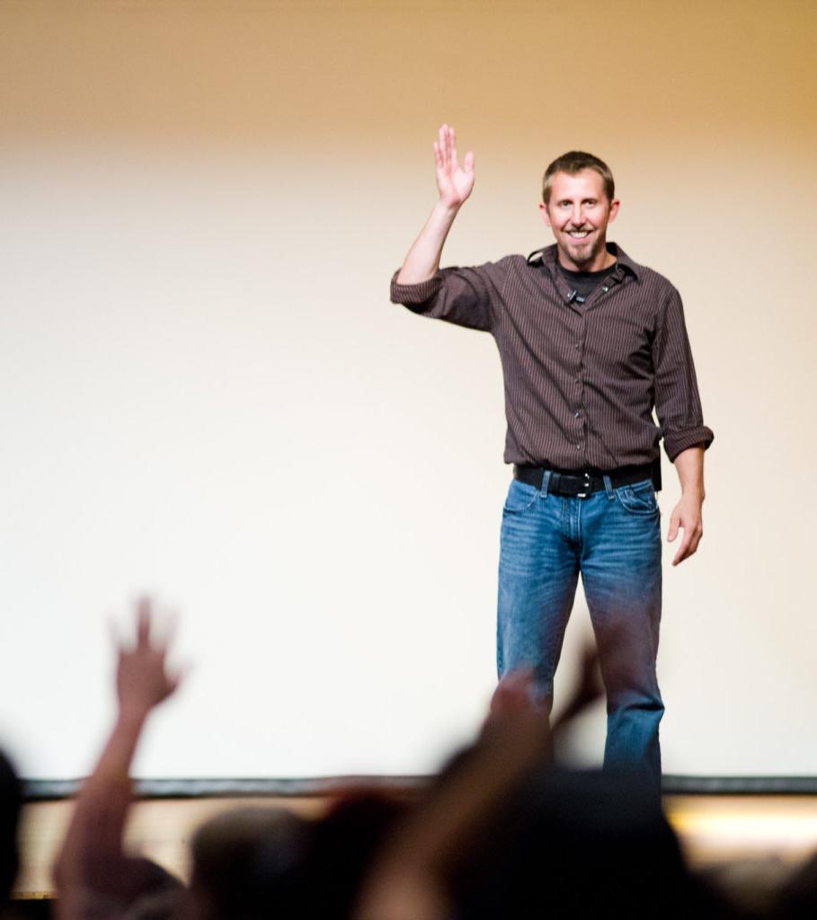 Man speaking to crowd on stage.